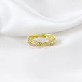 CZ X ring in 18k gold filled lying on white silk, crossover pavé band