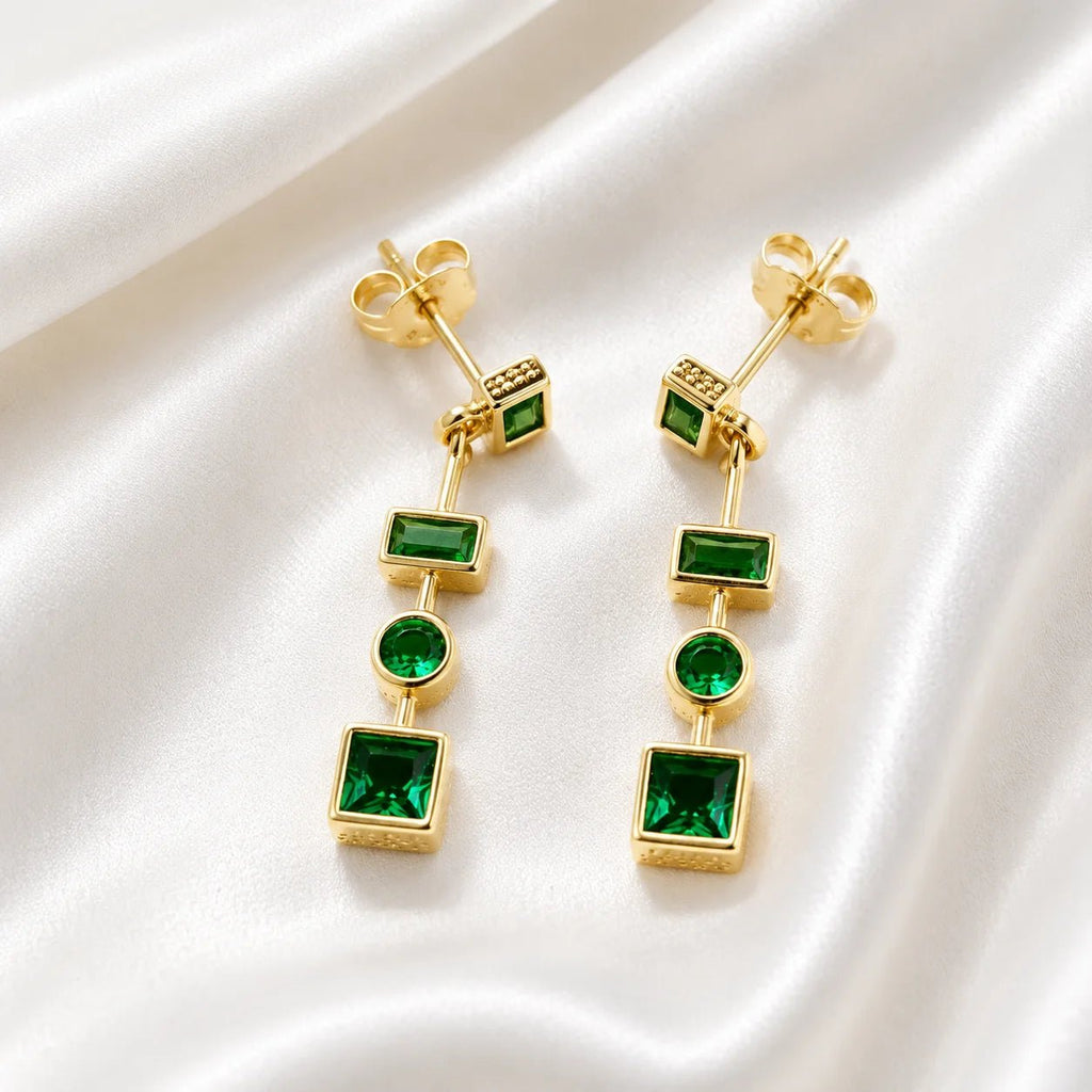 Emerald green CZ drop earrings with butterfly backs on ivory silk