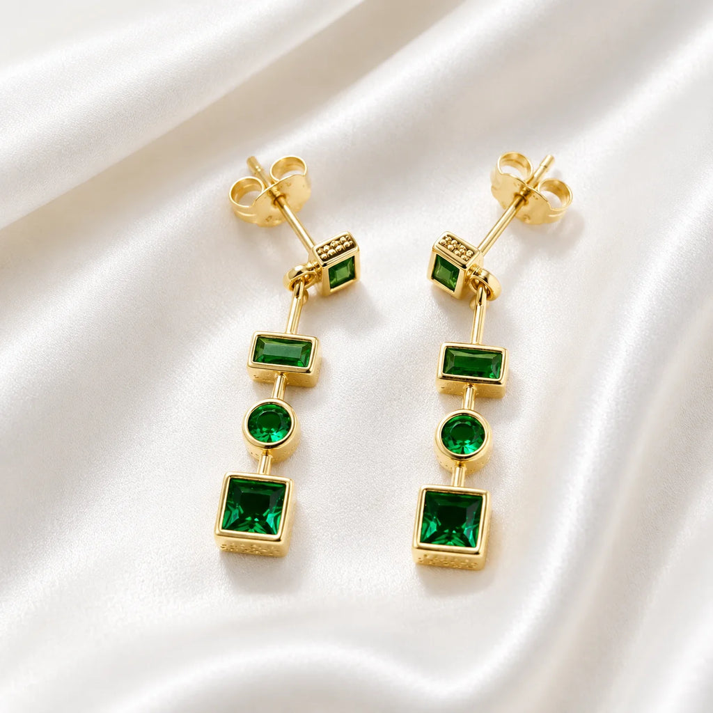 Close up of Ma Vie emerald drop earrings, multi-geometric bezel settings with green cubic zirconia