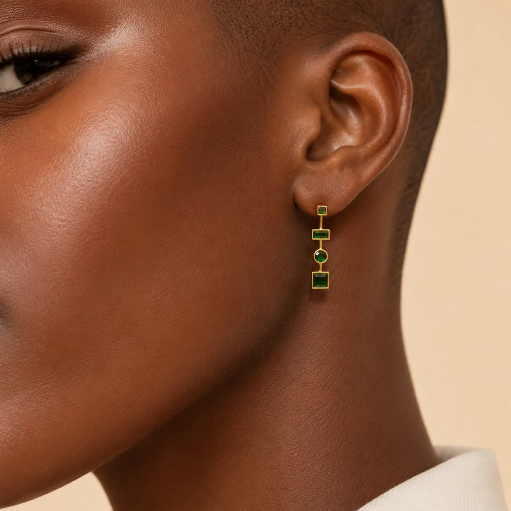 Woman wearing Ma Vie emerald drop earrings 18k gold filled with green CZ geometric design