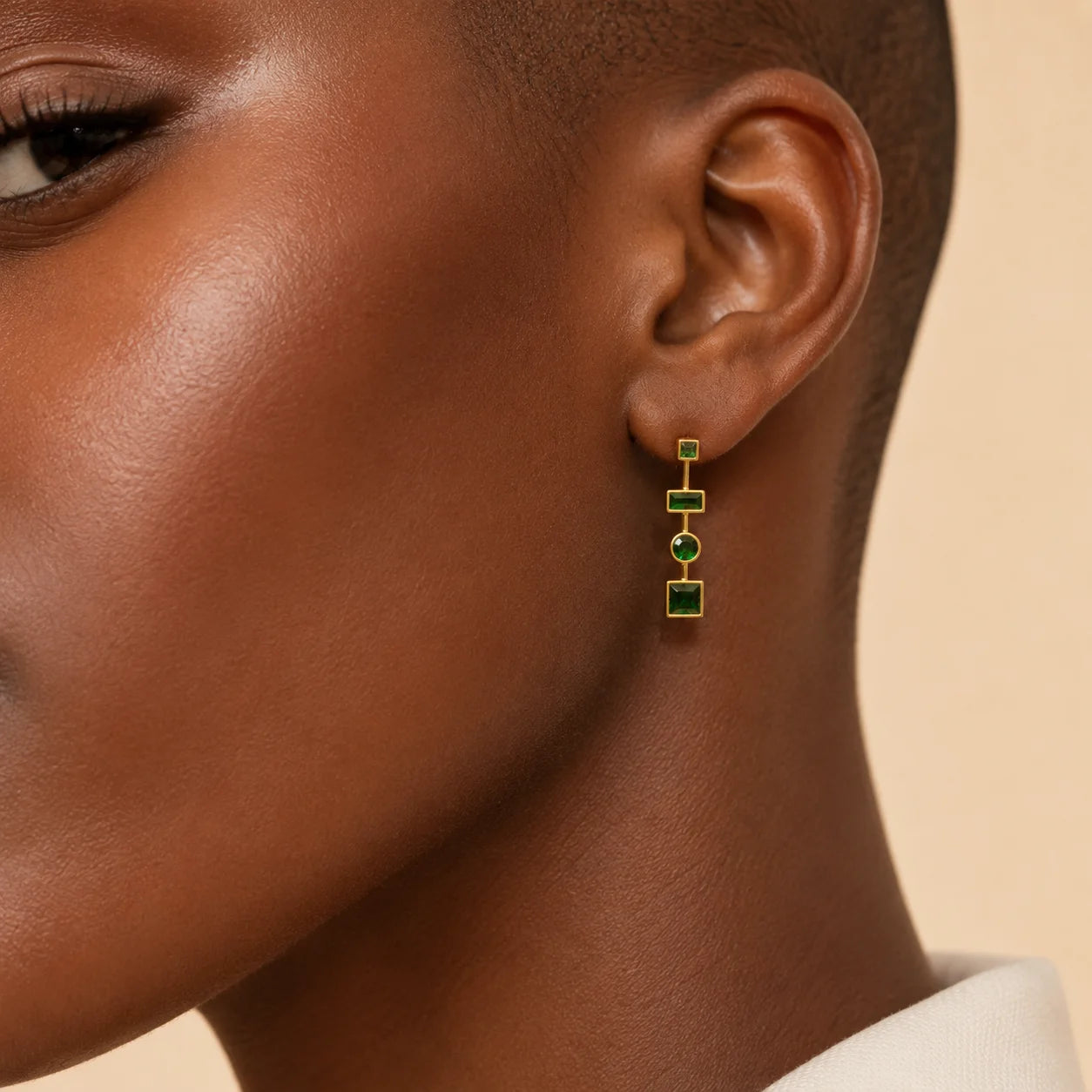 Woman wearing Ma Vie emerald drop earrings 18k gold filled with green CZ geometric design