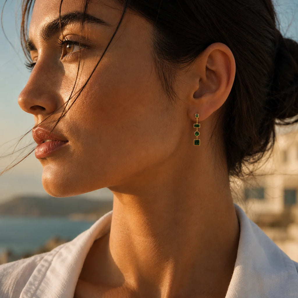 Side profile of woman wearing Ma Vie emerald drop earrings, 18k gold filled green CZ statement