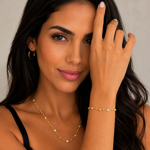 Gold beaded bracelet on model wrist, 18k gold filled with bezel CZ accents