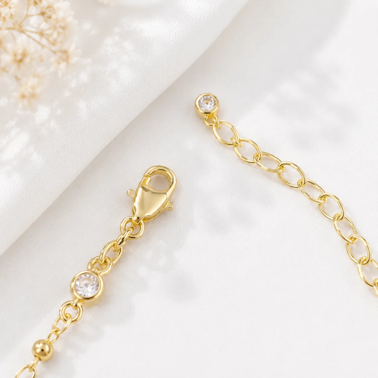 Gold filled bezel CZ stretch bracelet, polished gold beads on cream backdrop