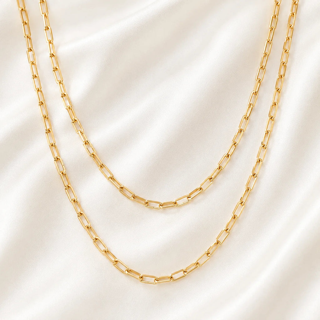 Close up of 18k gold filled paperclip link chain showing flat polished oval links on gold silk
