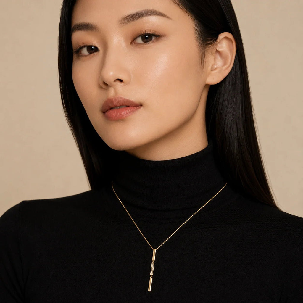 Model wearing linear triple bar drop necklace over a black turtleneck