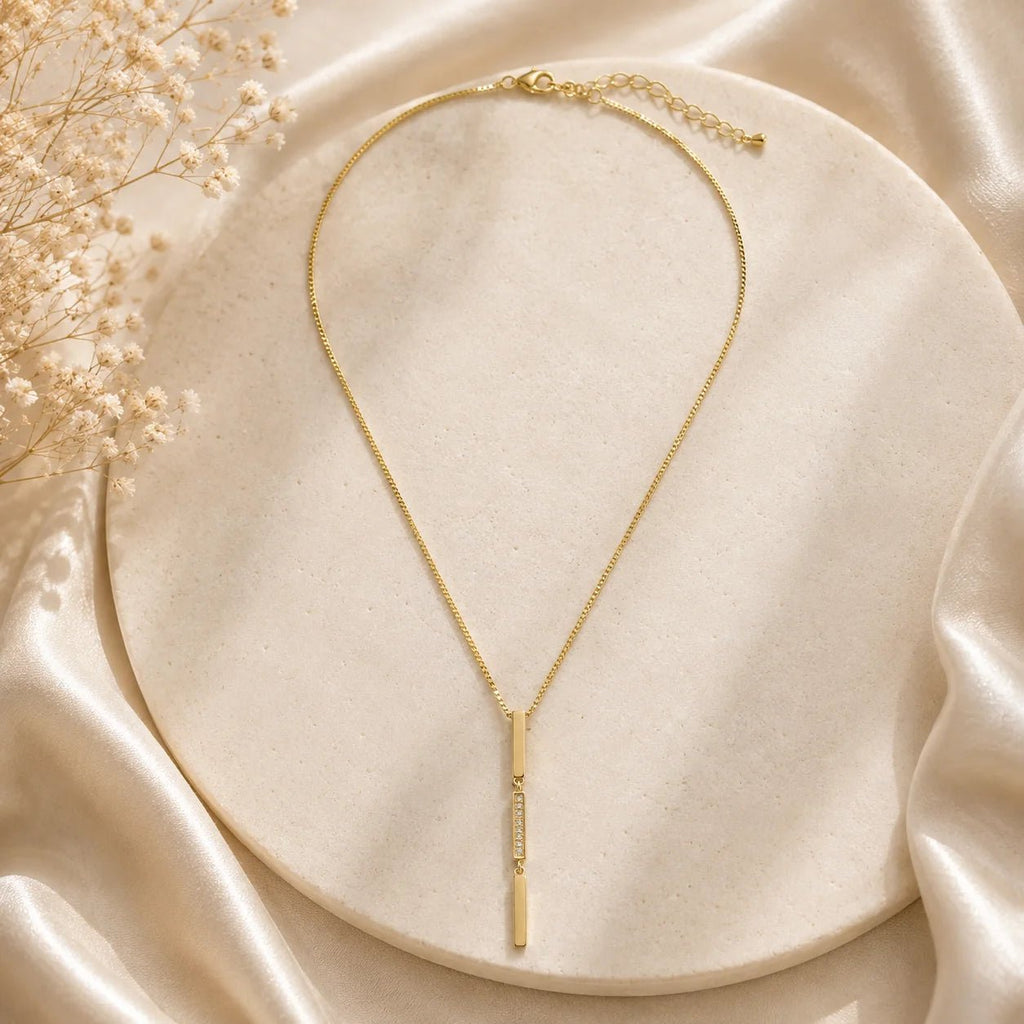 Full view of triple bar drop necklace with pavé CZ on cream silk
