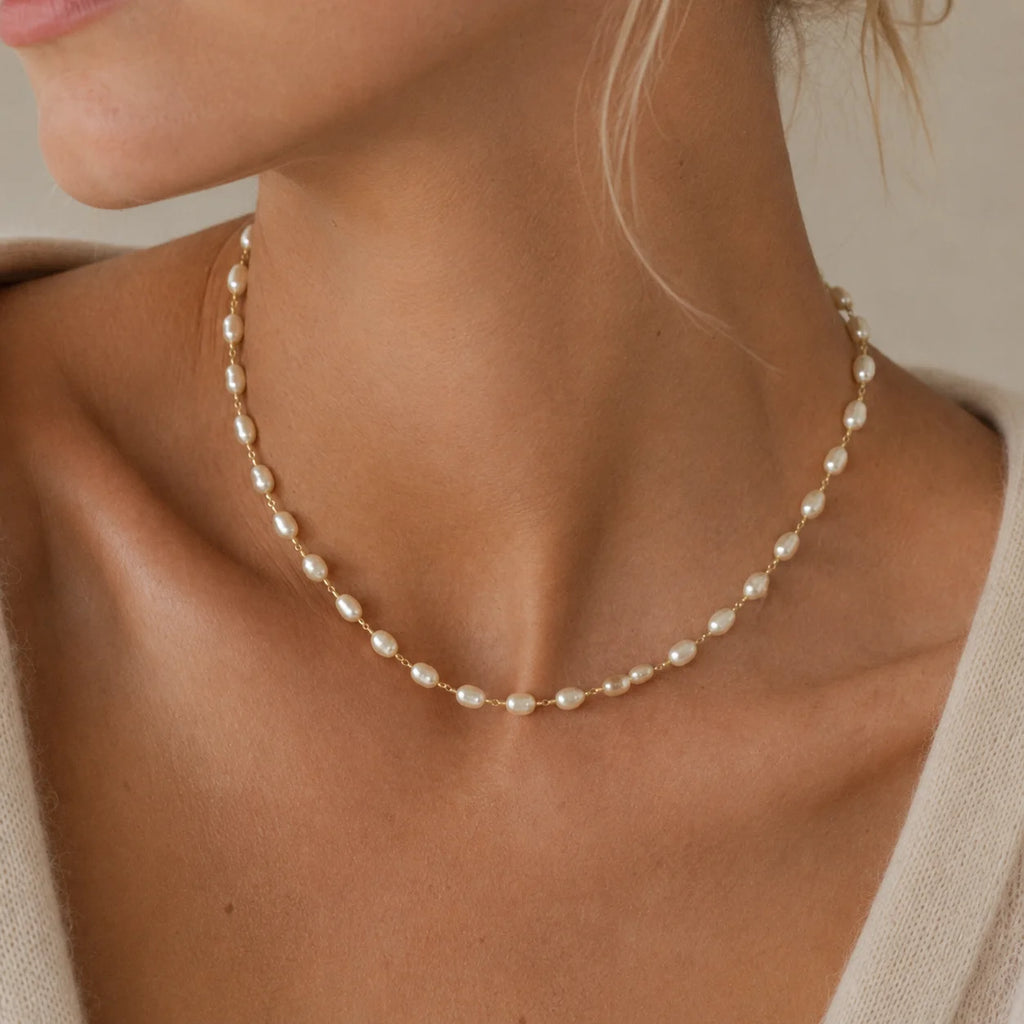 Woman wearing Ma Vie baroque pearl necklace in 18k gold filled, irregular pearls resting at the collarbone