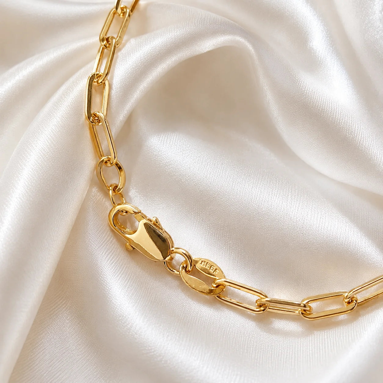 Ma Vie paperclip chain bracelet styled on cream silk fabric, 18k gold filled chain design