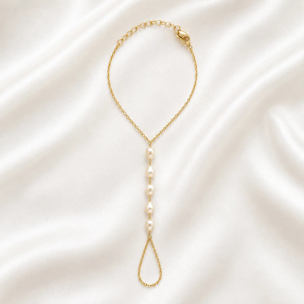 Close up of Ma Vie pearl hand chain bracelet, 18k gold filled with imitation baroque pearl charm