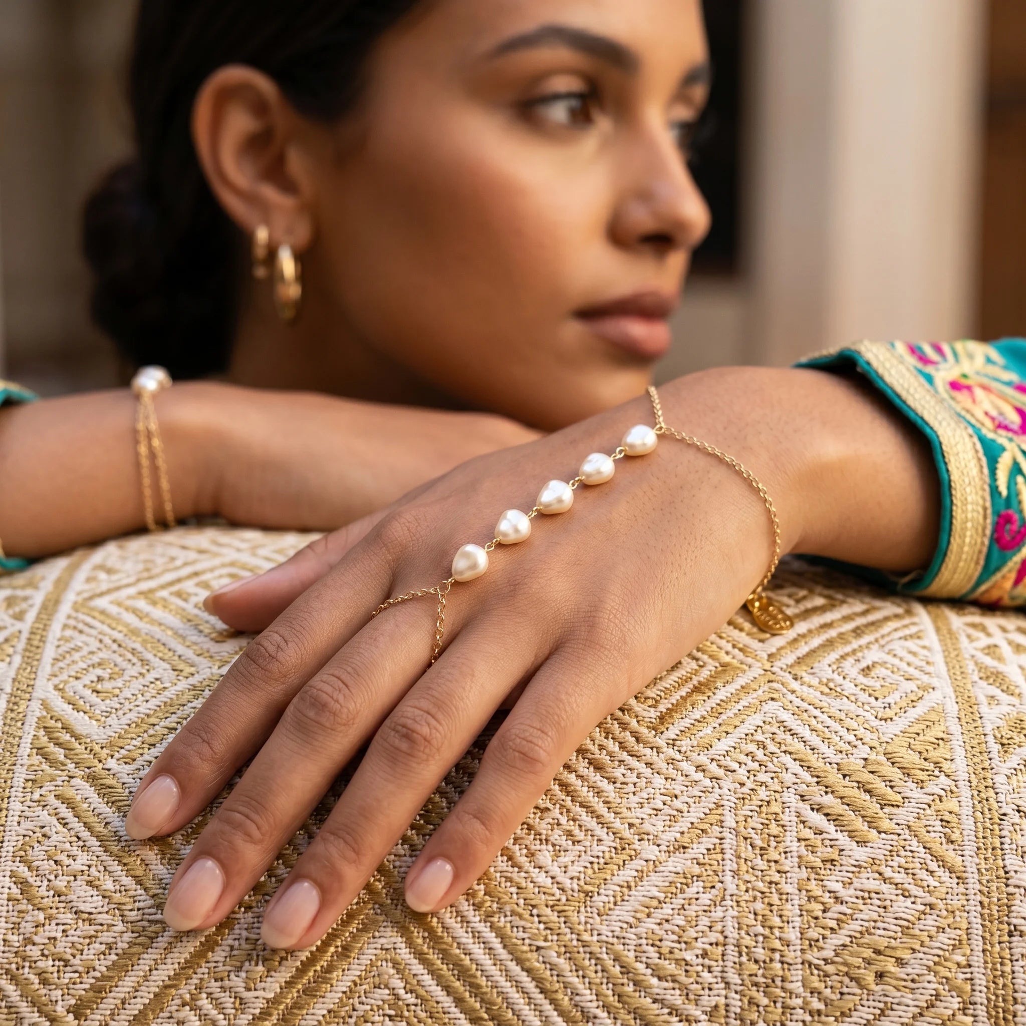 Woman wearing Ma Vie pearl hand chain bracelet, 18k gold filled with luminous baroque pearl detail