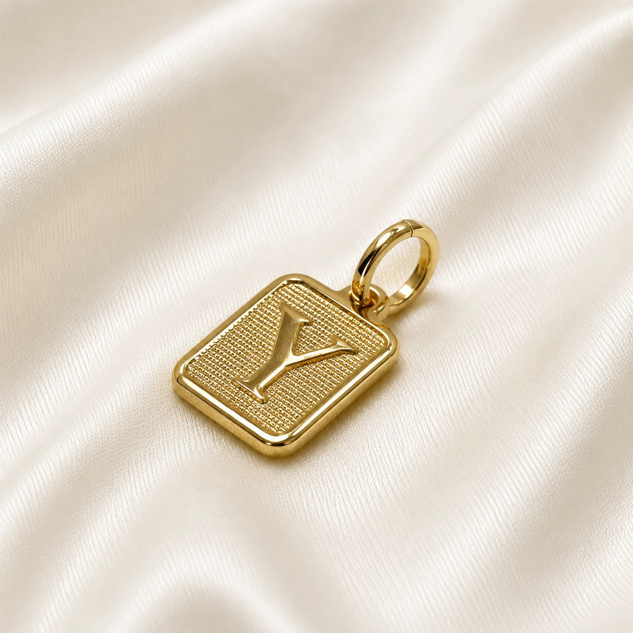 Personalized initial charm in gold filled standing on cream silk, square pendant
